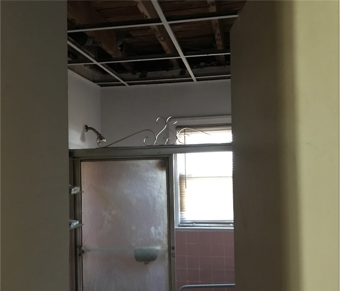 Bathroom with removed ceiling after fire loss.