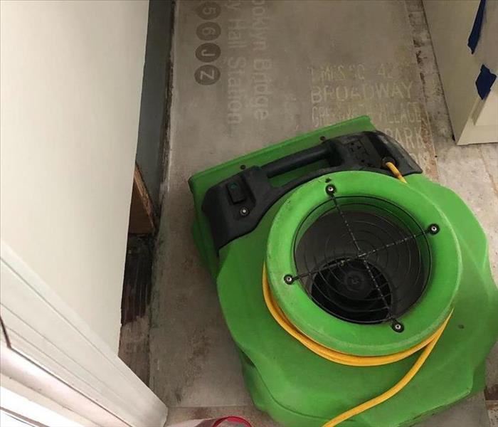 a piece of green drying equipment on a white floor 