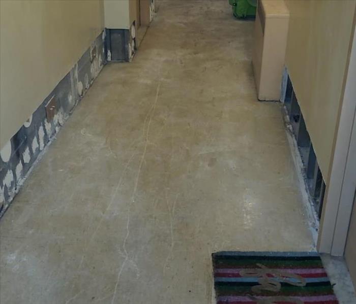 Commercial hallway with removed flooring and flood cuts.